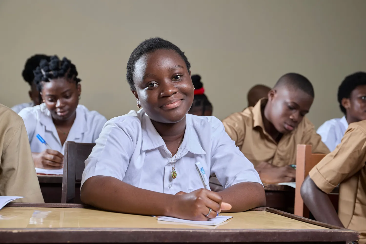 Élève camerounaise souriante en classe