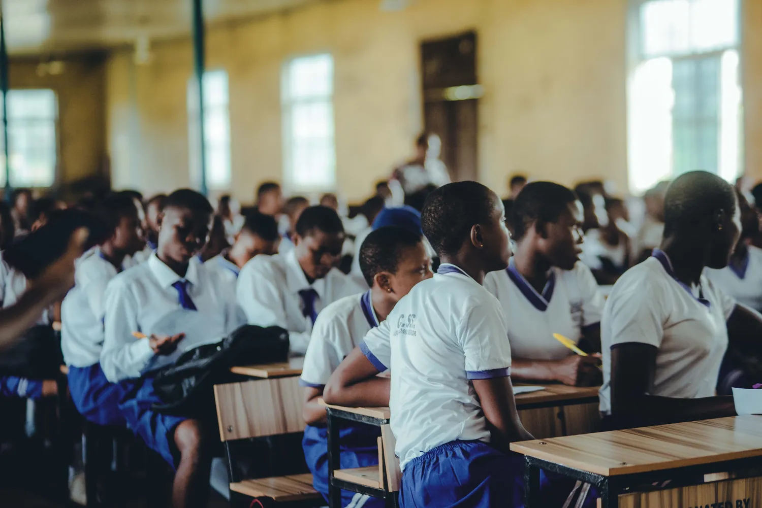 Élèves en composition dans une grande salle d'examen